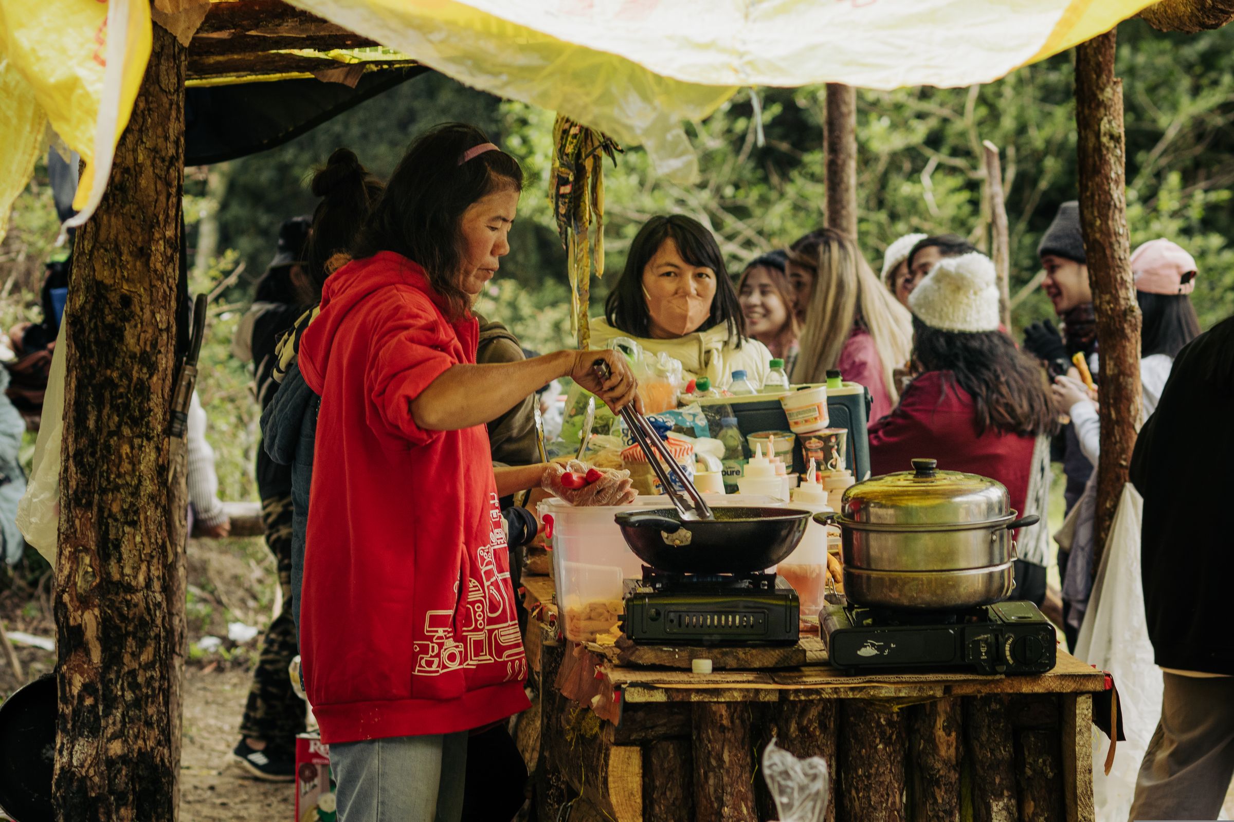 Perempuan menyiapkan makanan di stan kuliner